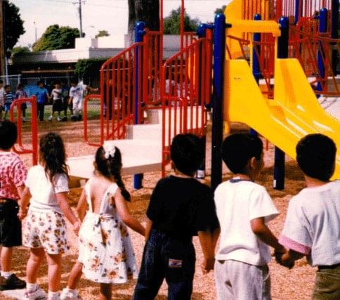 1994 Playground Equipment Renovation Project Children holding hands in front of a playground
