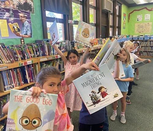 students-holding-books-in-a-library