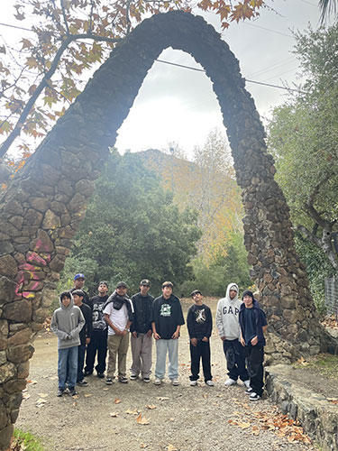 Niños del Círculo del Cóndor bajo un arco de piedra