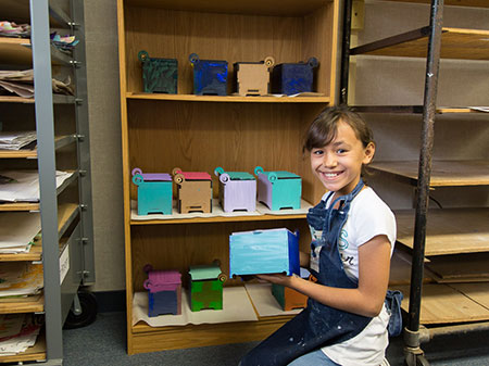 We-Care-Photo-home female student showing her craft project